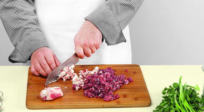 Используя массивный нож, нарежьте курдючное сало и баранину крупными кусками, затем порубите их до состояния фарша. Важно сохранить некоторые более крупные частицы мяса.