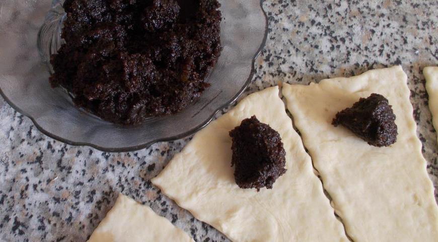На широкую часть каждого треугольника кладём чайную ложку маковой начинки. Она имеет приятный апельсиновый аромат благодаря натуральной цедре.