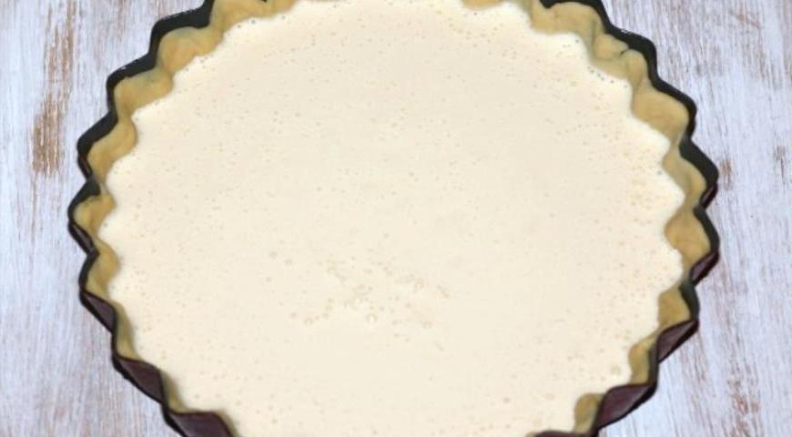 Разогрейте духовку до 180°C. Переложите сырную массу в подготовленную форму поверх коржа и аккуратно распределите по поверхности.