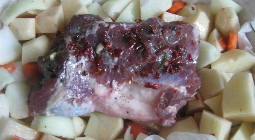 Уложите мясо поверх овощей, смажьте оставшимся оливковым маслом. Поставьте форму в предварительно разогретую духовку и запекайте около 40 минут, пока мясо не зарумянится.