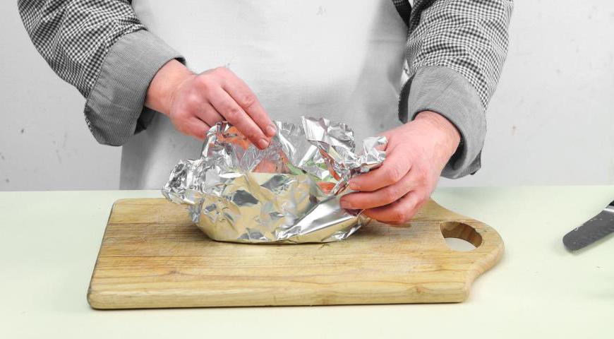 Подготовьте 4 квадратных куска фольги. На каждый выложите по 2 ломтика фенхеля. Поместите на них по одному рыбному стейку, затем добавьте чеснок сверху. Полейте все чесночным маслом.