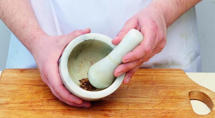Включите духовку на температуру 185 °C. Измельчите можжевельник и душистый перец в ступке до состояния порошка.