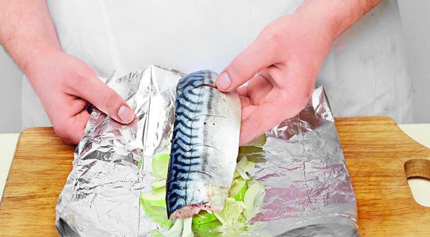 Приготовьте два двойных куска фольги размером примерно 21×31 см. На каждый положите подготовленные яблочные, луковые и лимонные слои, затем филе рыбы.