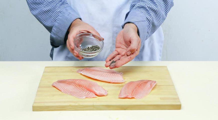 Начните с подготовки всех продуктов. Разогрейте духовку до 170 °C. Тилапию хорошо промойте и обсушите бумажным полотенцем. Посолите и поперчите по вкусу. Для начинки мелко порубите петрушку, чеснок, анчоусы и каперсы, чтобы получить ароматную массу.