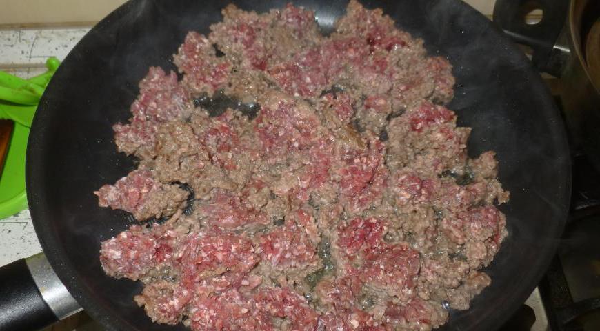 В разогретой сковороде обжарьте говяжий фарш до золотистой корочки, помешивая и разбивая комки. Добавьте соль и перец по вкусу.